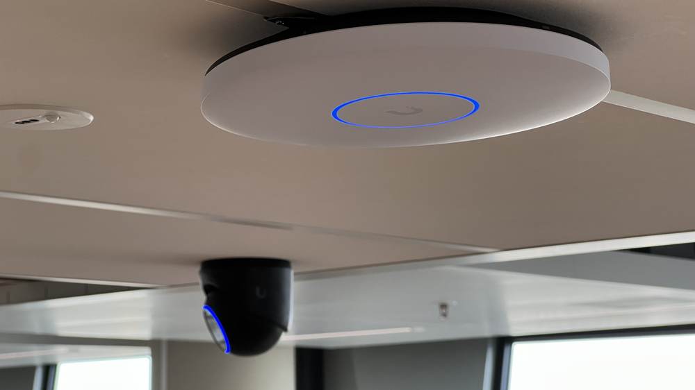 UniFi access point en camera naast elkaar aan hetzelfde plafond