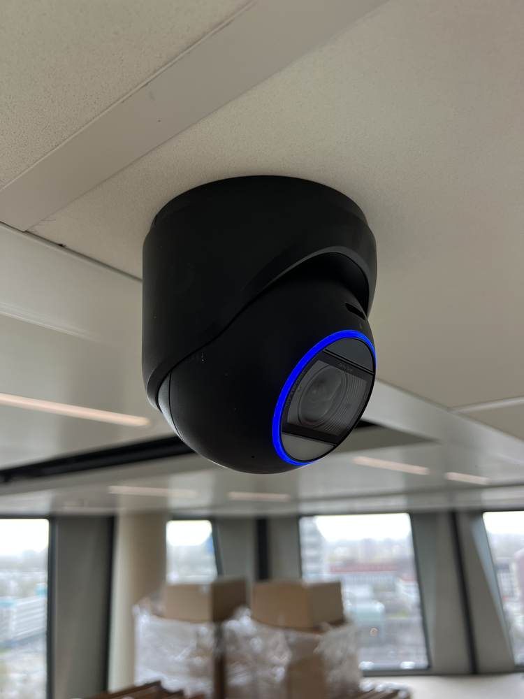 UniFi turret-camera aan het plafond van een kantoorruimte
