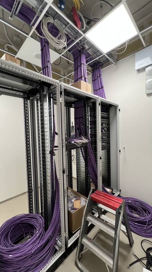 Centrale serverkast met gepatchte netwerkbekabeling in kabelgoten