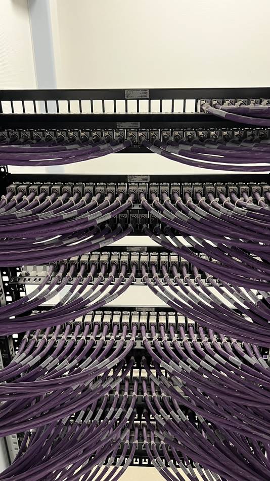 Close-up van een netjes bekabeld patchpaneel met gepatchte netwerkkabels