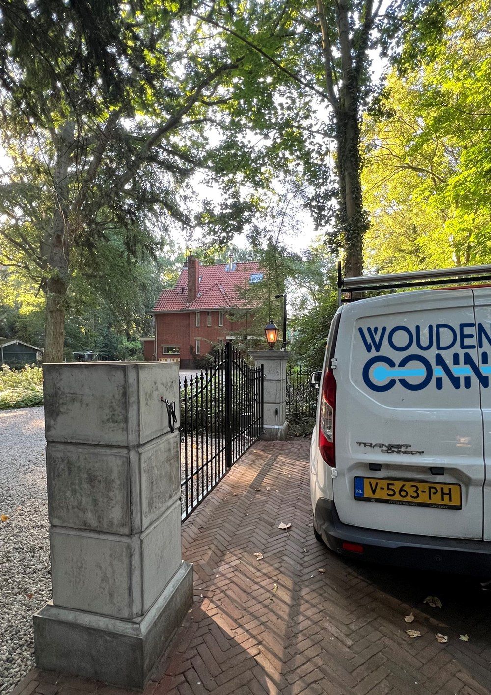 Bedrijfsbusje van Woudenberg Connect bij een oprit, camera-installatie Delft