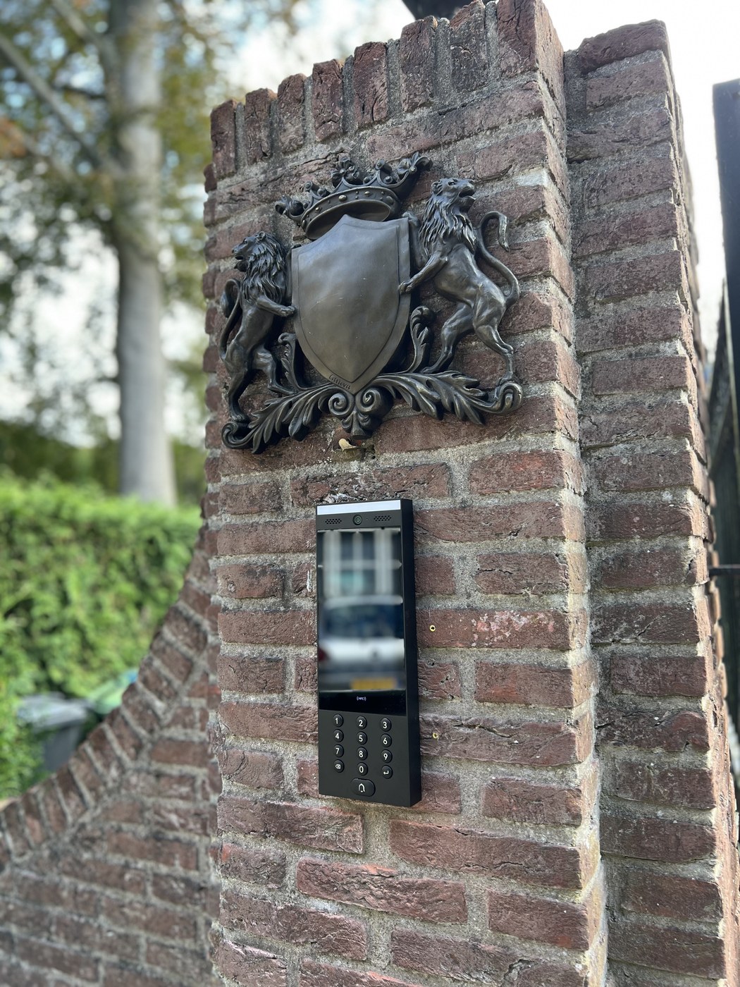 UniFi Access-lezer gemonteerd op een pilaar bij een toegangspoort
