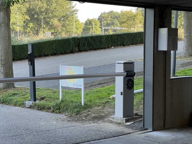 Slagboom met UniFi Access-lezer bij de ingang van een parkeerterrein